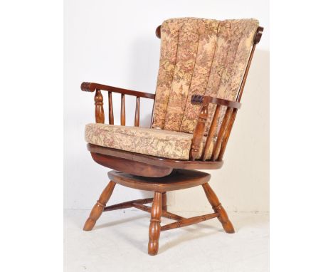 A late 20th century Windsor style armchair / easy chair. The chair having curved top rail with turned spindles, shaped armres