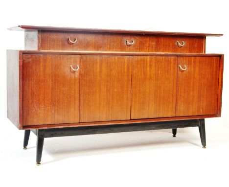 A retro vintage E Gomme / G Plan Tola wood sideboard having a floating shelf over a run of three drawers atop bi fold cupboar