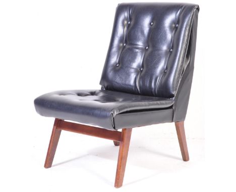 A retro vintage mid 20th century cocktail / accent chair upholstered in black leatherette having scalloped sides raised on te