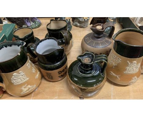 A collection of Royal Doulton salt glazed stoneware hunting jugs and flagons to include seven examples for Dewars Whisky (3 w