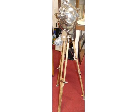 An industrial style chromed spotlight lamp on wooden tripod base