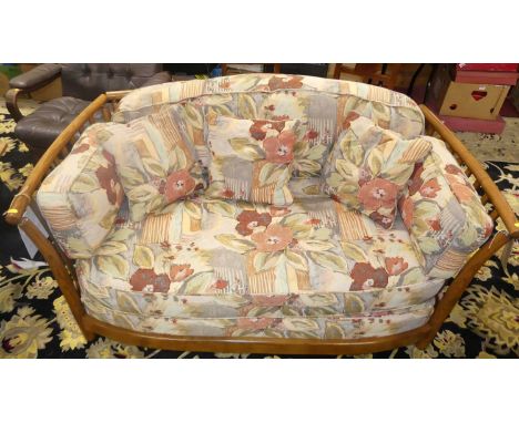 An Ercol mid-elm two-seater sofa, having slatback and sides, bright coloured cushioned upholstery, w.140cm 