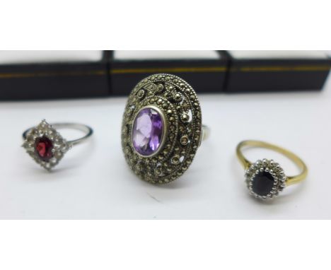 Three rings; a 9ct gold and midnight blue sapphire cluster ring; an attractive large silver marcasite dress ring with purple 