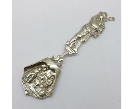 An early 20th Century German silver caddy spoon by Berthold Muller with the handle depicting a musician playing the bagpipes,