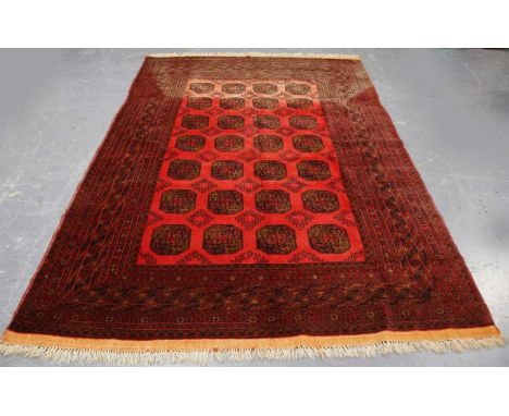 An Afghan bokhara style carpet, late 20th century, the shaded pale plum field with overall guls, within a multiple border, 29