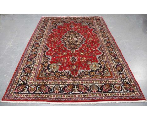A Tabriz carpet, North-west Persia, late 20th century, the red field with a shaped medallion, within a palmette border, 285cm