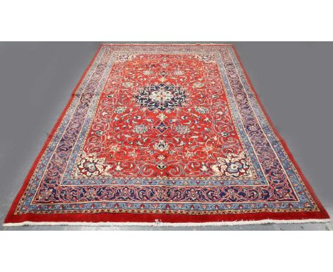 A Sarough carpet, Central Persia, late 20th century, the red field with a flowerhead medallion, within a scrolling vine borde