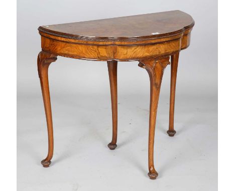 An early 20th century walnut fold-over card table, the shaped top above carved cabriole legs, height 73cm, width 84cm, depth 