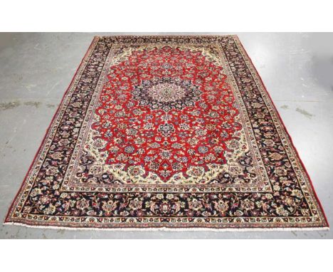 A Central Persian carpet, late 20th century, the red field with a flowerhead medallion, profusely supported by foliage, withi