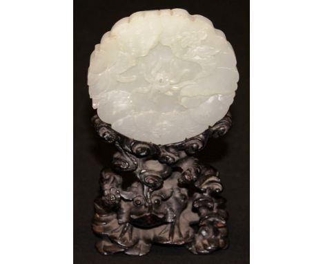 A 19th Century Chinese jade disc decorated with spider amongst flowers and with lotus flower carved verso, raised on a lacque