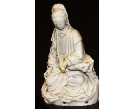 A 17th Century Chinese blanc-de-chine figure of Guan Yin in lotus position, holding a scroll in her left hand (hand a replace