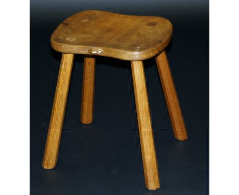 An oak stool by Robert Thompson The Mouseman, the shaped top with signature mouse, raised on four splayed chamfered supports,