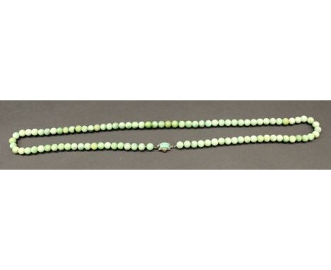 An early 20th Century jade bead necklace with Art Deco style jade clasp mount, 86 cm long CONDITION REPORTS Clasp is stamped 