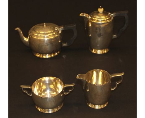 A George VI silver four piece tea set comprising teapot, hot water pot, milk jug and sucrier with stylised cloud shaped handl