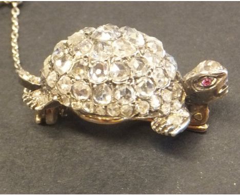 A diamond brooch in the form of a tortoise with domed back and ruby set eyes, 3 cm long CONDITION REPORTS Some general wear. 