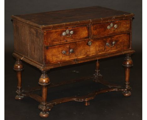 A walnut chest in the William & Mary manner, the quartered top feathered and cross banded with moulded edge above two short a