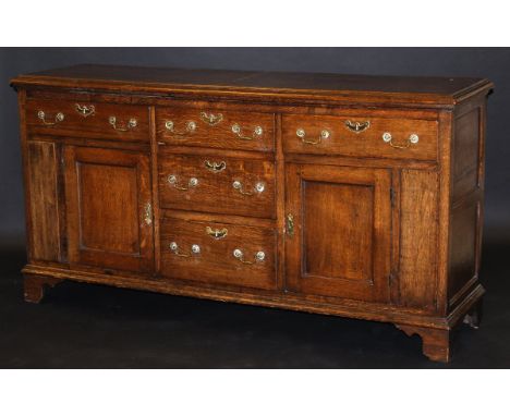 A circa 1800 oak dresser, the top with moulded edge above a central bank of three drawers flanked by single drawers over pane