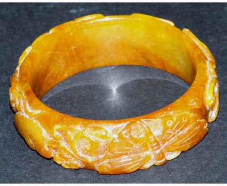 A yellow jade bangle with carved butterfly and dragon decoration, 7 cm diameter, approx 71 g