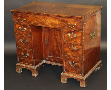 A George III mahogany dressing table, the double rising lid with moulded edge opening to reveal a fitted interior with variou