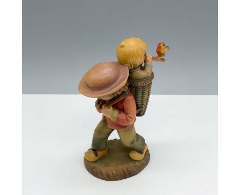 Marvelous hand carved figure of a boy wearing a basket backpack as he carries a younger boy who is playing the flute. Anri ba