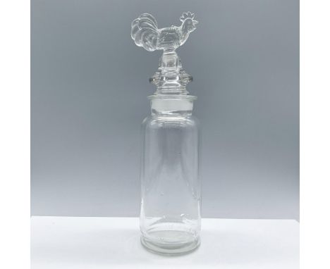 A beautiful clear glass bottle crafted as a three-in-one piece, combining the bottle, strainer, and stopper, and adorned with