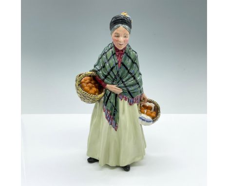 Hand decorated and hand painted figure of an elderly woman carrying to large baskets filled with oranges. Light green, dark g