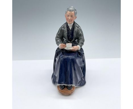 Hand decorated and hand made figure of a seated elderly woman with a cup of tea. Dark blue and gray colorations. Royal Doulto