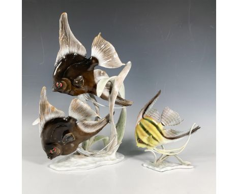 This set includes two glossy porcelain figurines including two brown and one striped yellow angel fish swimming through seawe