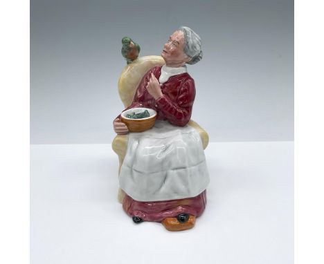 Hand decorated and hand made figure of a seated elderly woman feeding peas to her pet parrot. Royal Doulton backstamp. Artist