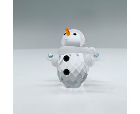 A clear crystal figure of a snowman with his arms wide open holding two snowballs that are made of light blue crystals. An or