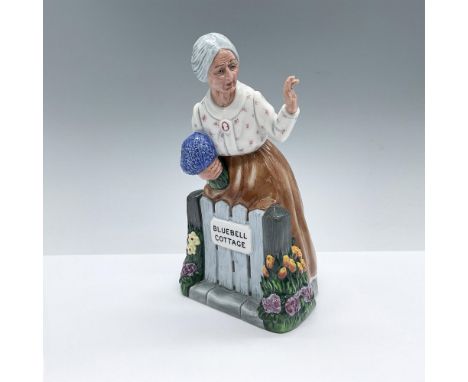 Hand made and hand decorated figure of an elderly woman leaning over her fencing with a bouquet of flower, waving. Beautiful 