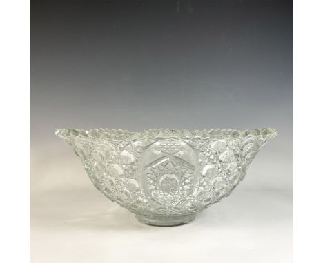 Clear glass punch bowl with intricate glass cut designs featuring octagon, diamond and star patterns, and accented with a bea