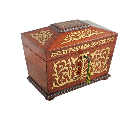 A Regency rosewood and brass inlaid sarcophagus shaped tea caddy, the hinged cover opening to reveal two lidded tea compartme