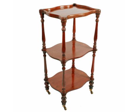 A Victorian mahogany three tier étagère, c.1850, the serpentine-shaped shelves with turned supports, the top shelf with galle