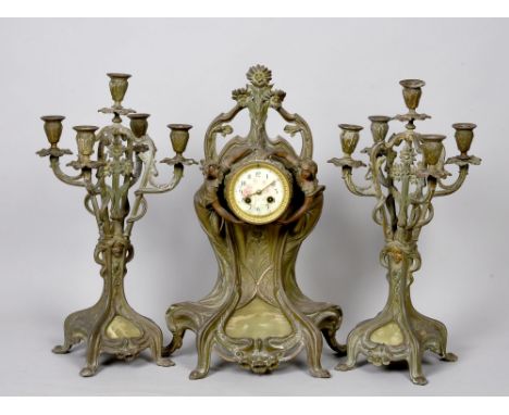 A late 19c French Garniture de Cheminee comprising a clock and two candelabra in the Art Nouveau style.  The clock is two tra