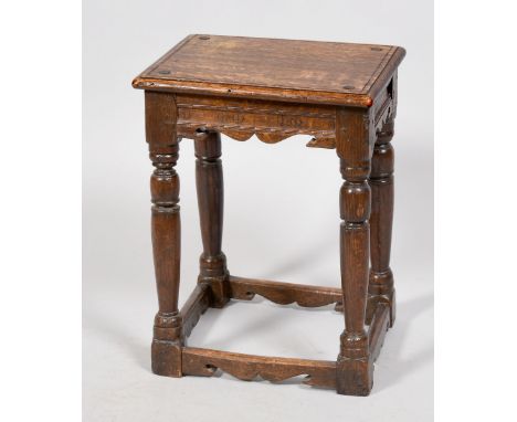 A late 17c/early 18c oak joint stool of rectangular form with moulded edge, carved seat rails with baluster ring turned sligh