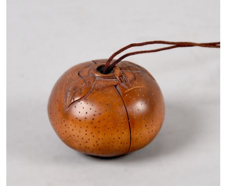 A Japanese carved nut netsuke hinged and opening to reveal a pig devouring a basket of fruit.