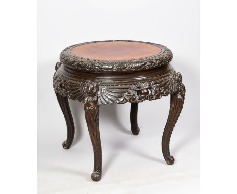 A 19c Chinese carved hardwood and black lacquered circular centre table, dragon and scroll work carved and supported on four 