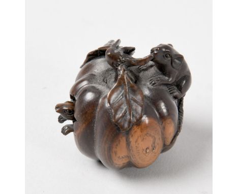 A Japanese carved wood netsuke in the form of a melon containing a rat together with one rat seated on the outside eating a l