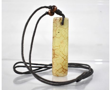 A Jade Pendant of Elongated Form, 70mm by 18mm on Cotton Cord Necklace 
