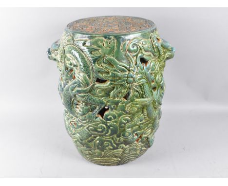 A Chinese Glazed Stoneware Cylindrical Seat with Heavy Relief Decoration Depicting Dragons, 30cms Diameter and 42cms High 