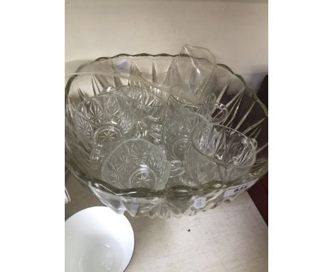 A glass punchbowl with ladle and cups 