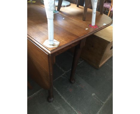 An oak gate leg table with pad feet. 