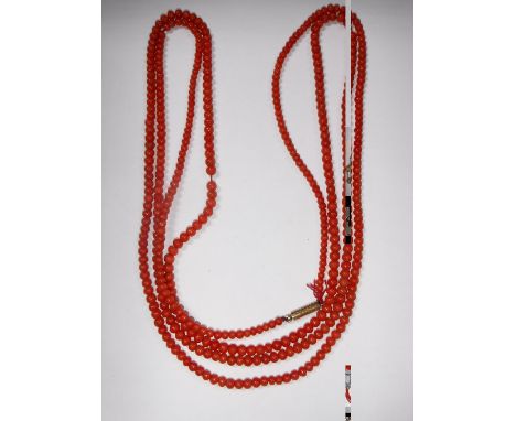 A LONG 'CORAL' BEADED NECKLACE with gold clasp, circa 31"
