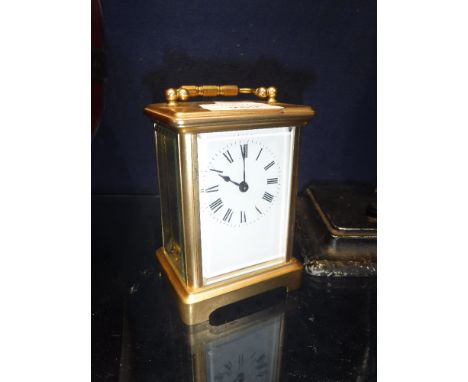 A LATE VICTORIAN/EDWARDIAN GILT BRASS CARRIAGE CLOCK with bevelled glass panels and enamel dial, 4.5" high