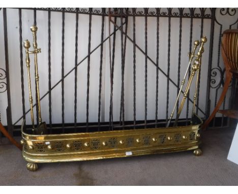  A 19TH CENTURY BRASS FENDER with original brass fire tools