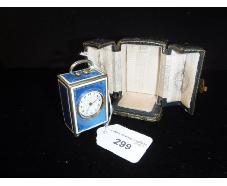 A MINIATURE SILVER AND ENAMEL CARRIAGE CLOCK, the blue and white enamel case with a hinged door enclosing movement on bun fee