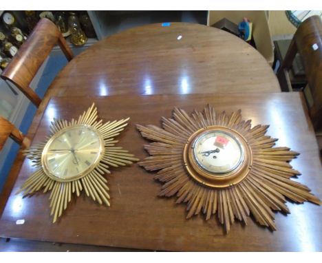 A gilt wood Sunburst wall clock with an Empire movement, silvered dial with Arabic numerals, and a Junghans ATO-MAT gilt bras