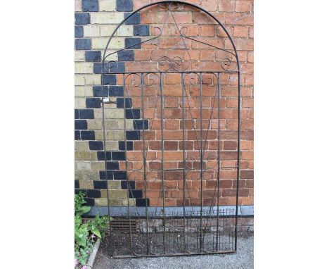 A wrought metal arched top garden gate