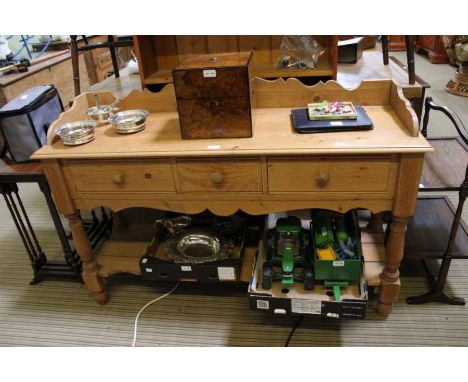 A pine dresser base with three inline drawers and planked pot shelf